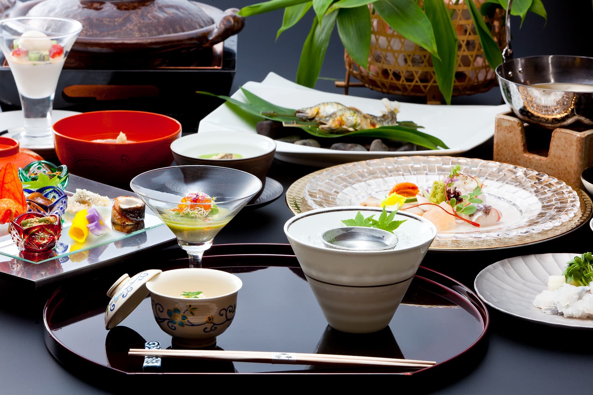 Kinzan multi-course kaiseki dinner laid out on a black lacquer tray with steamed egg custard, sashimi, grilled fish and small seasonal dishes