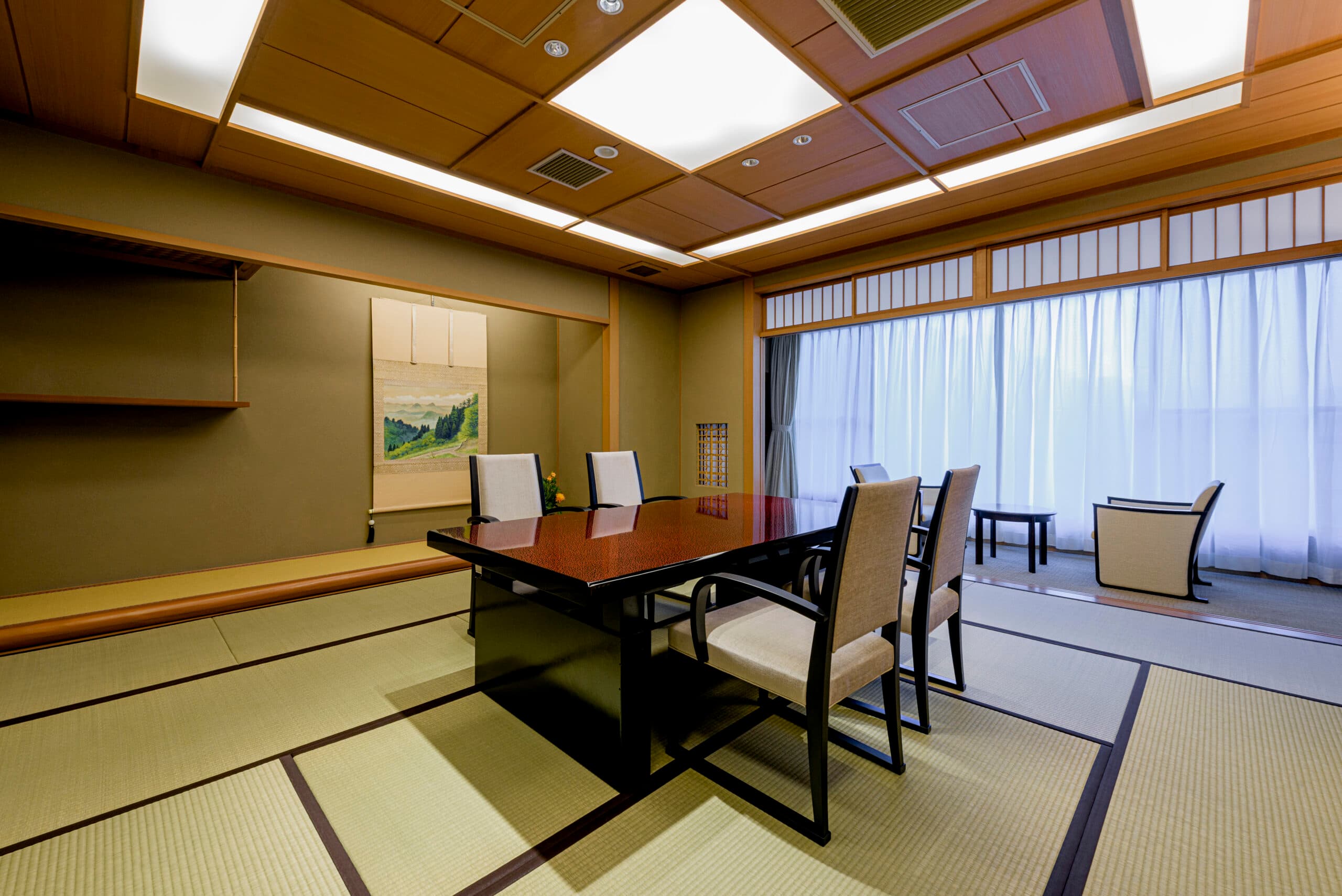 Modern Japanese-Western guest room at Kinzan with a private dining table set against warm wood paneling