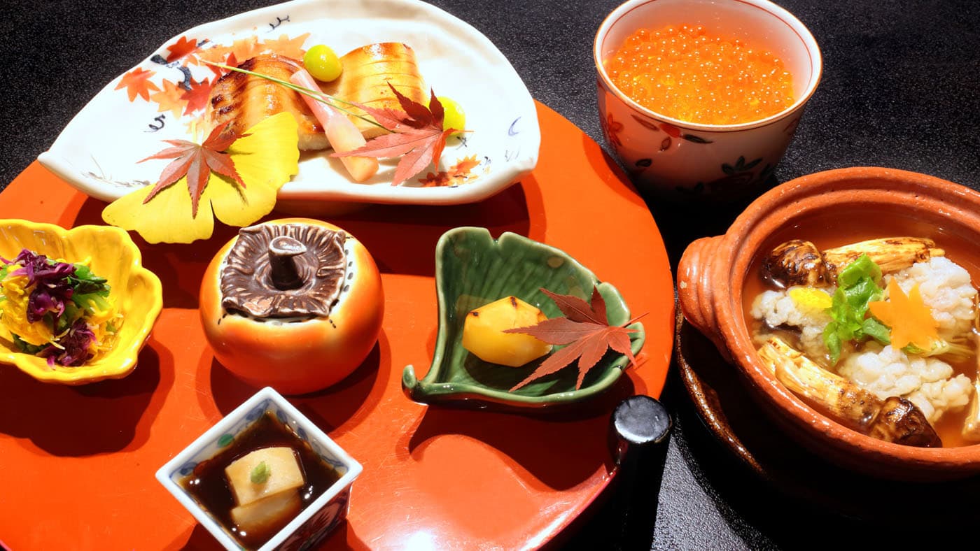 Autumn kaiseki course with grilled fish, seasonal small dishes and maple leaf garnish on a red lacquer tray at Atami Koarashitei