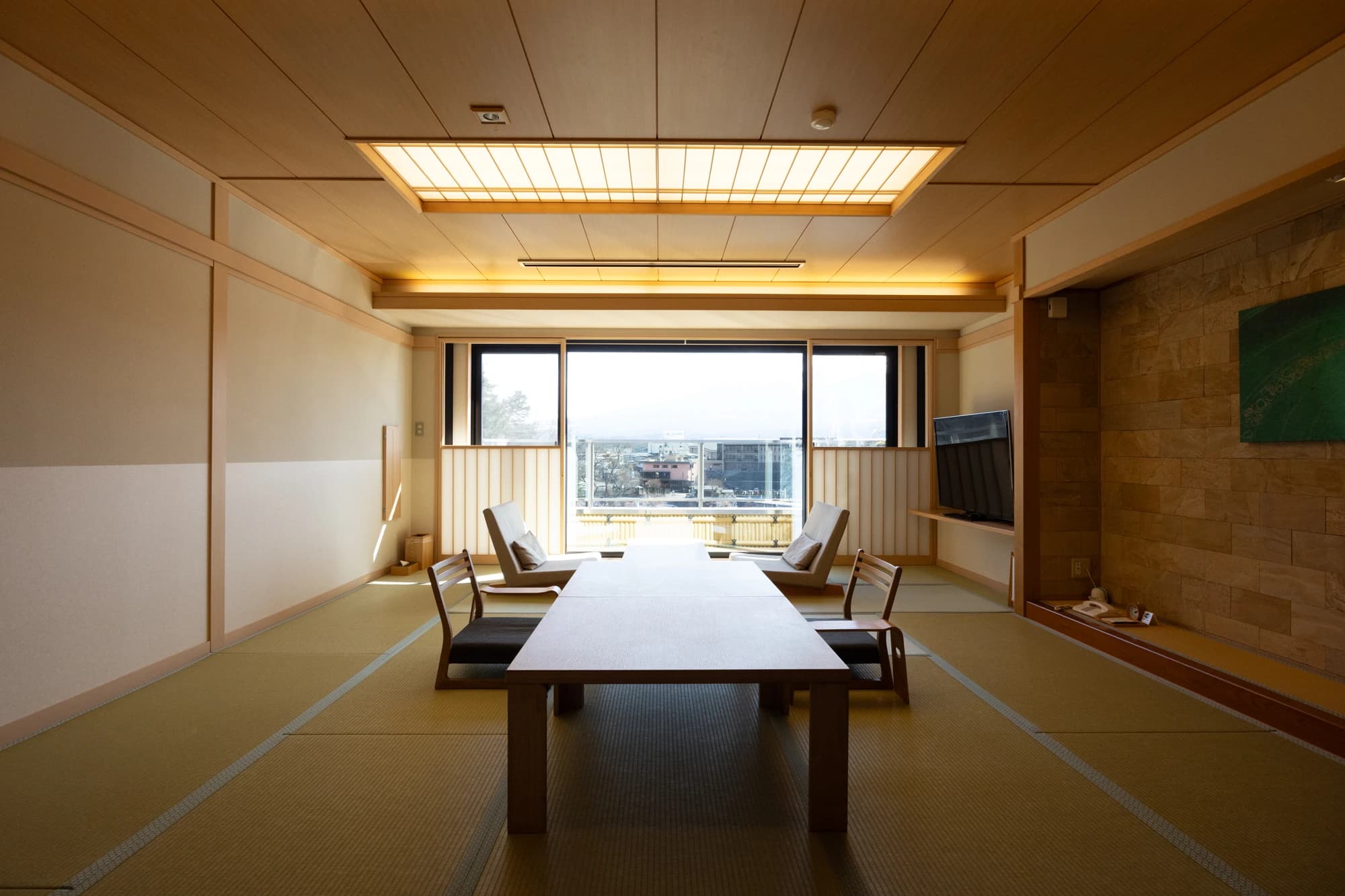 Bright tatami guest room at Konansou with recessed lighting and a window view of Mt Fuji and the surrounding town