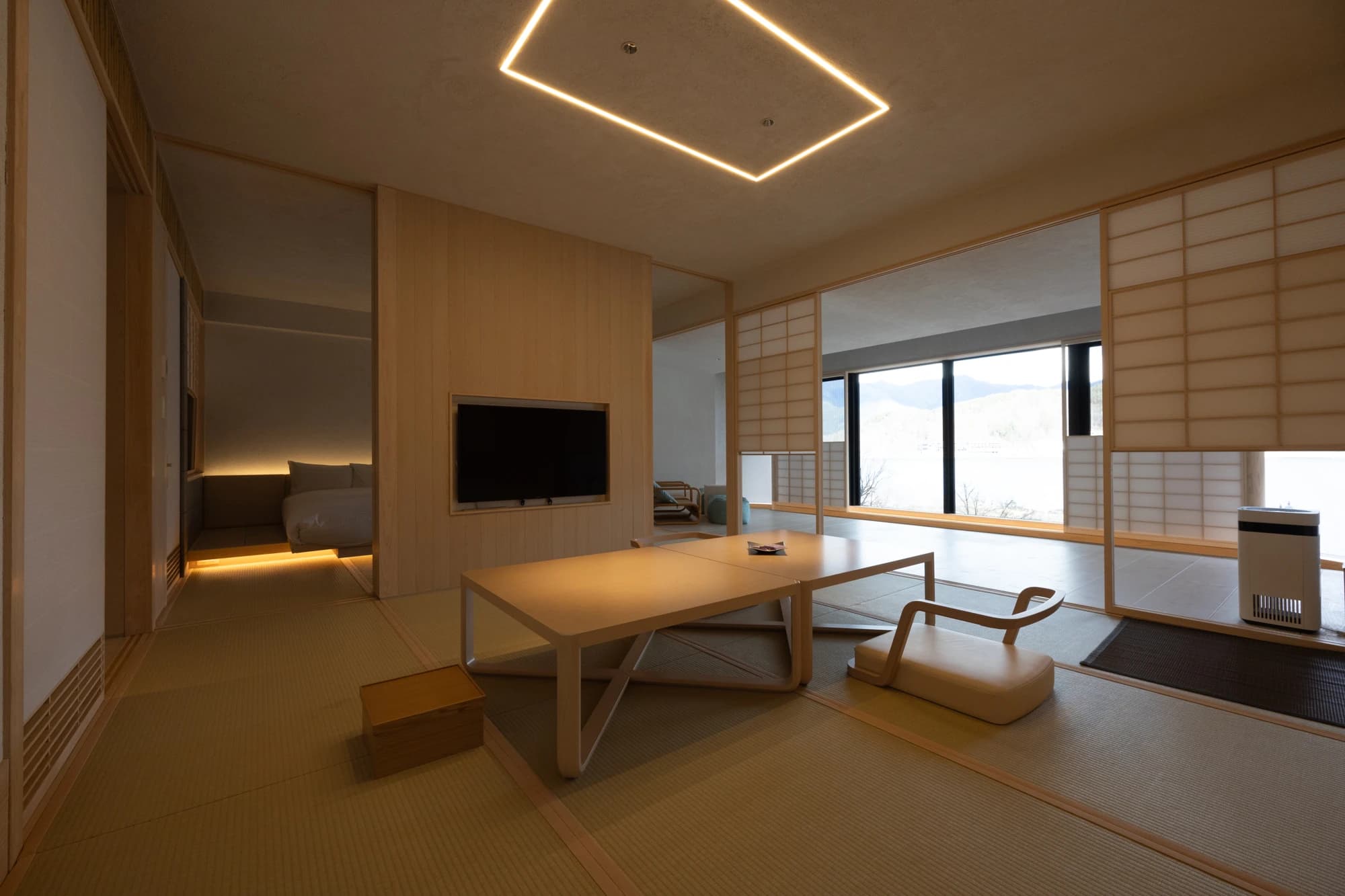 Spacious modern Japanese-style suite at Konansou with tatami flooring and wide windows opening to a lake view