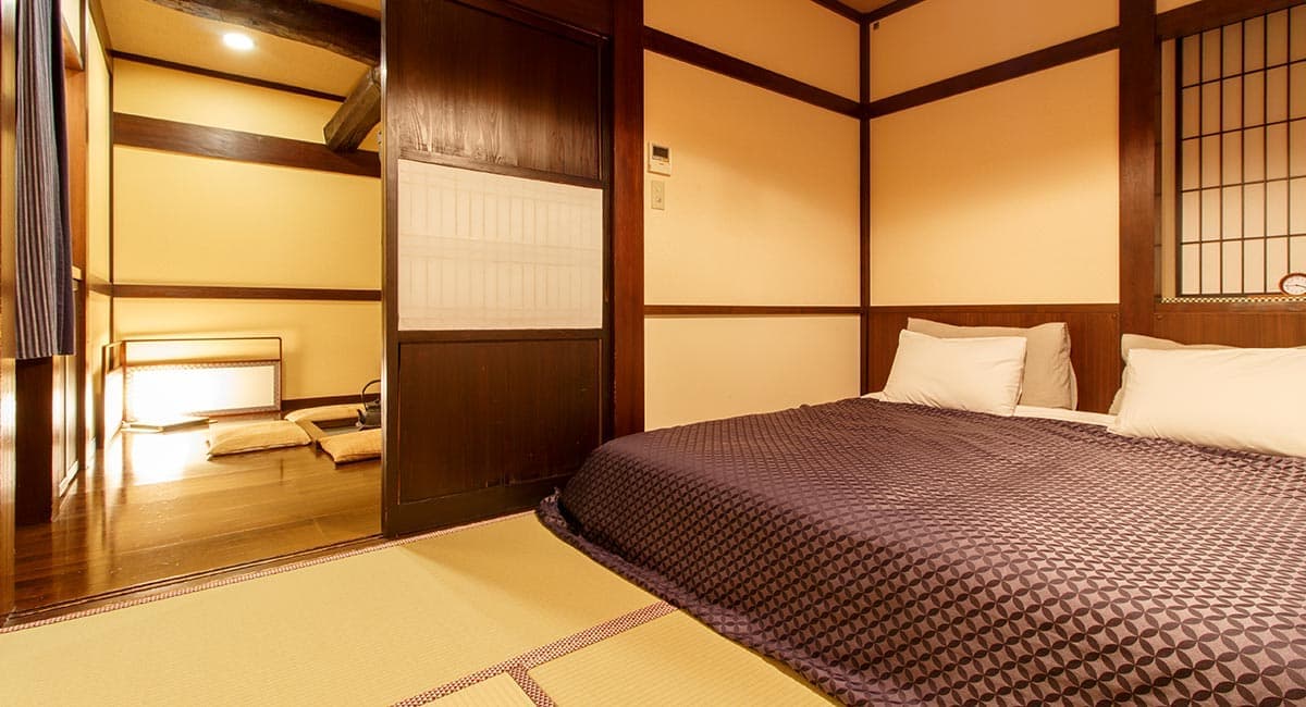 Tatami guest room with double bed and adjoining sitting area in a heritage timber-frame building at Oyado Koto no Yume, Takayama