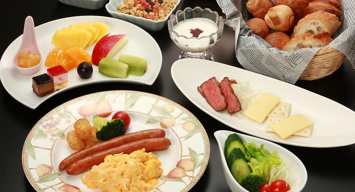 Breakfast spread with eggs, sausages, fresh bread, fruit and cheese at Oyado Koto no Yume in Takayama