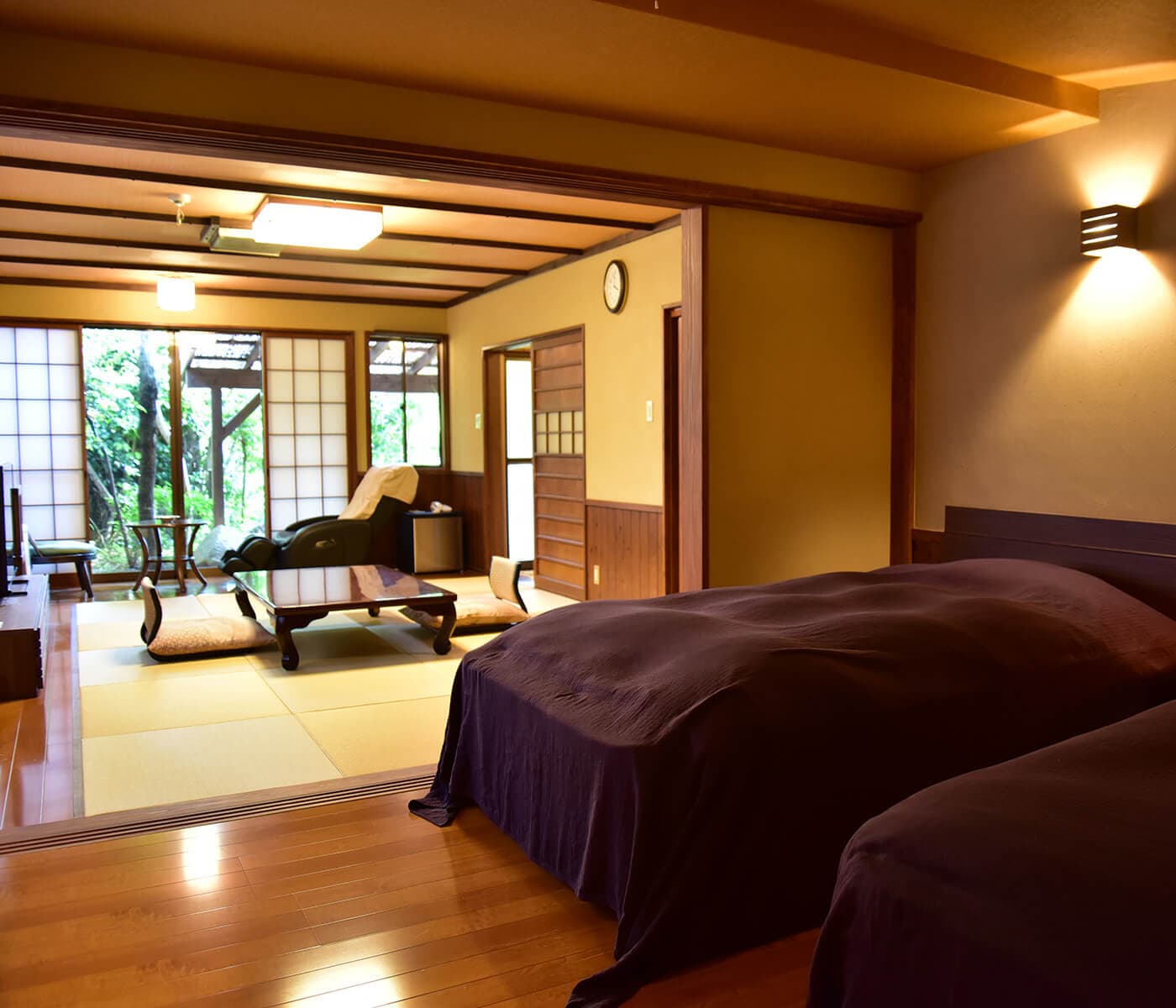 Guest room with low table and garden view at Ryokan Kounoyu