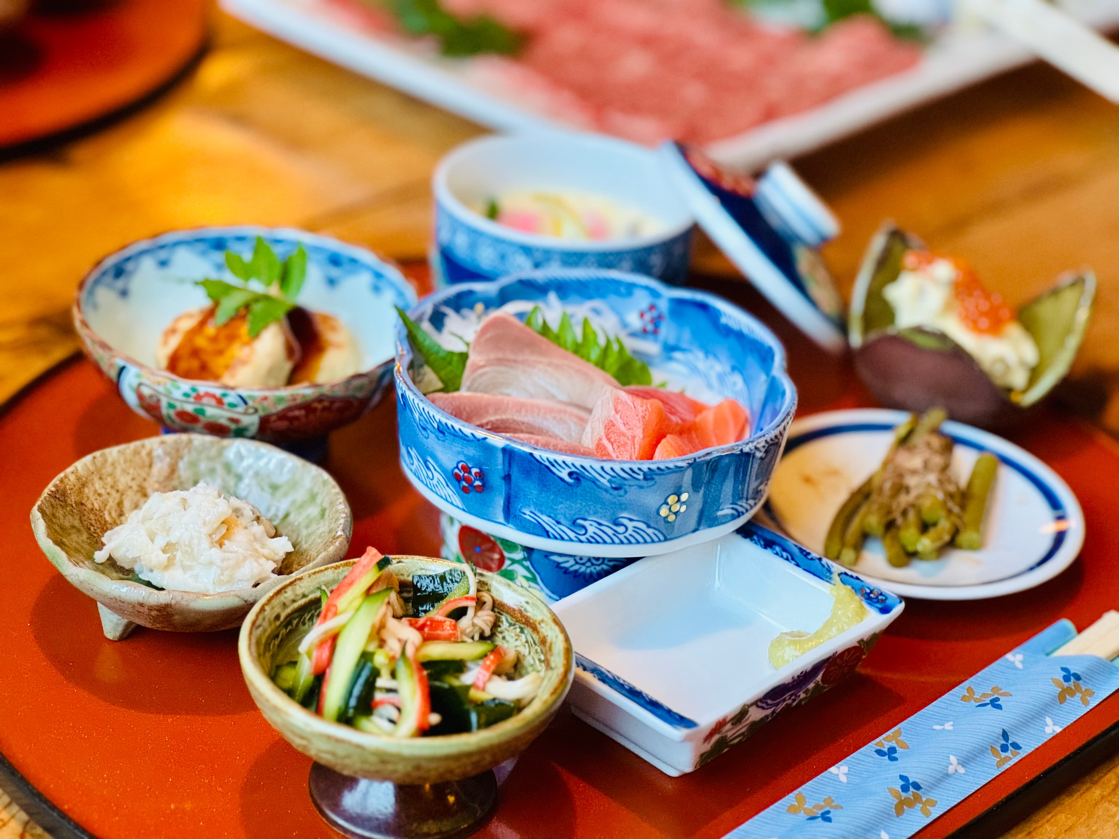 Japanese kaiseki dinner spread with sashimi and small dishes on a lacquer tray at Matsunoki-tei