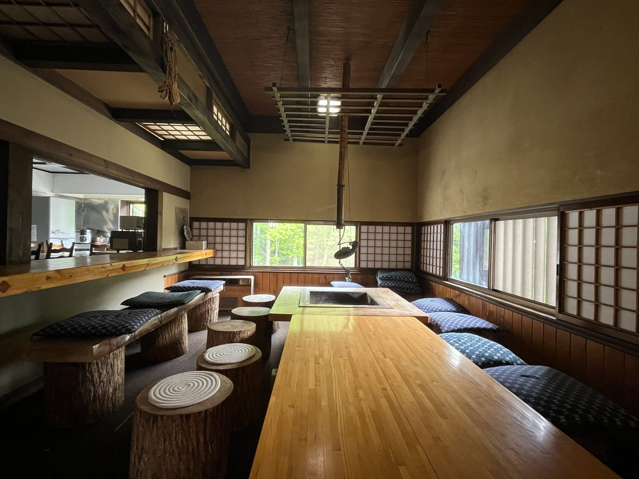 Detached cottage bedroom with exposed dark beams and paper lanterns at Matsunoki-tei