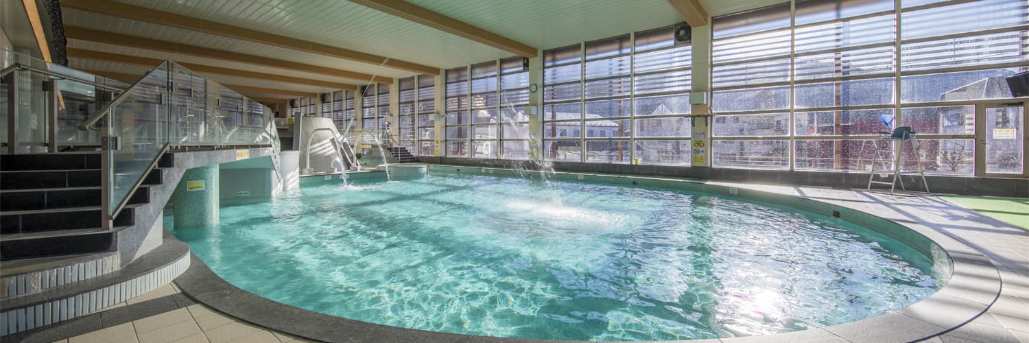 Large indoor swimwear spa pool with garden windows