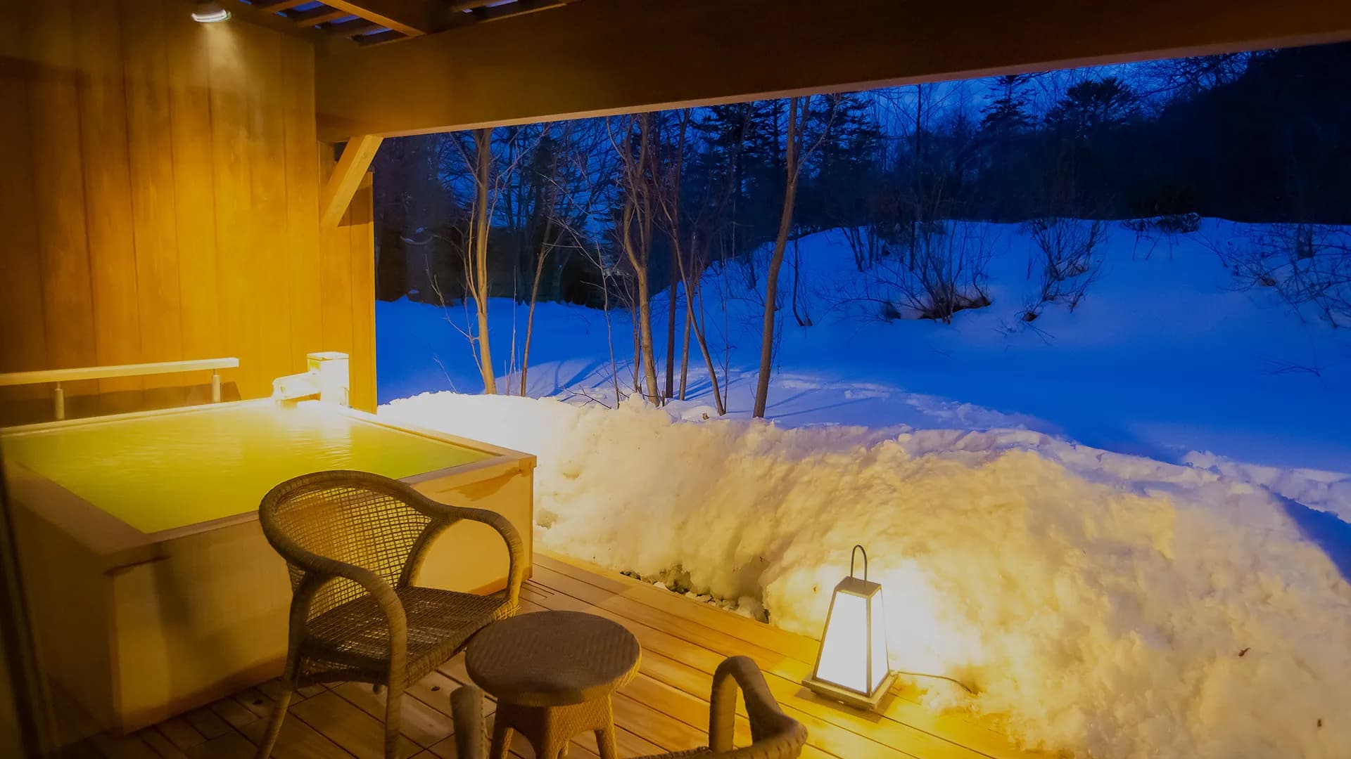 Private guest-room terrace hot spring tub overlooking deep snow at dusk at Oku Nikko Mori no Hotel