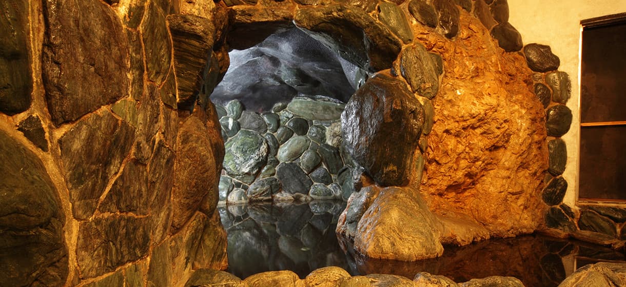 Indoor cave-style stone bath at Morizuya carved into natural rock with still reflective hot-spring water