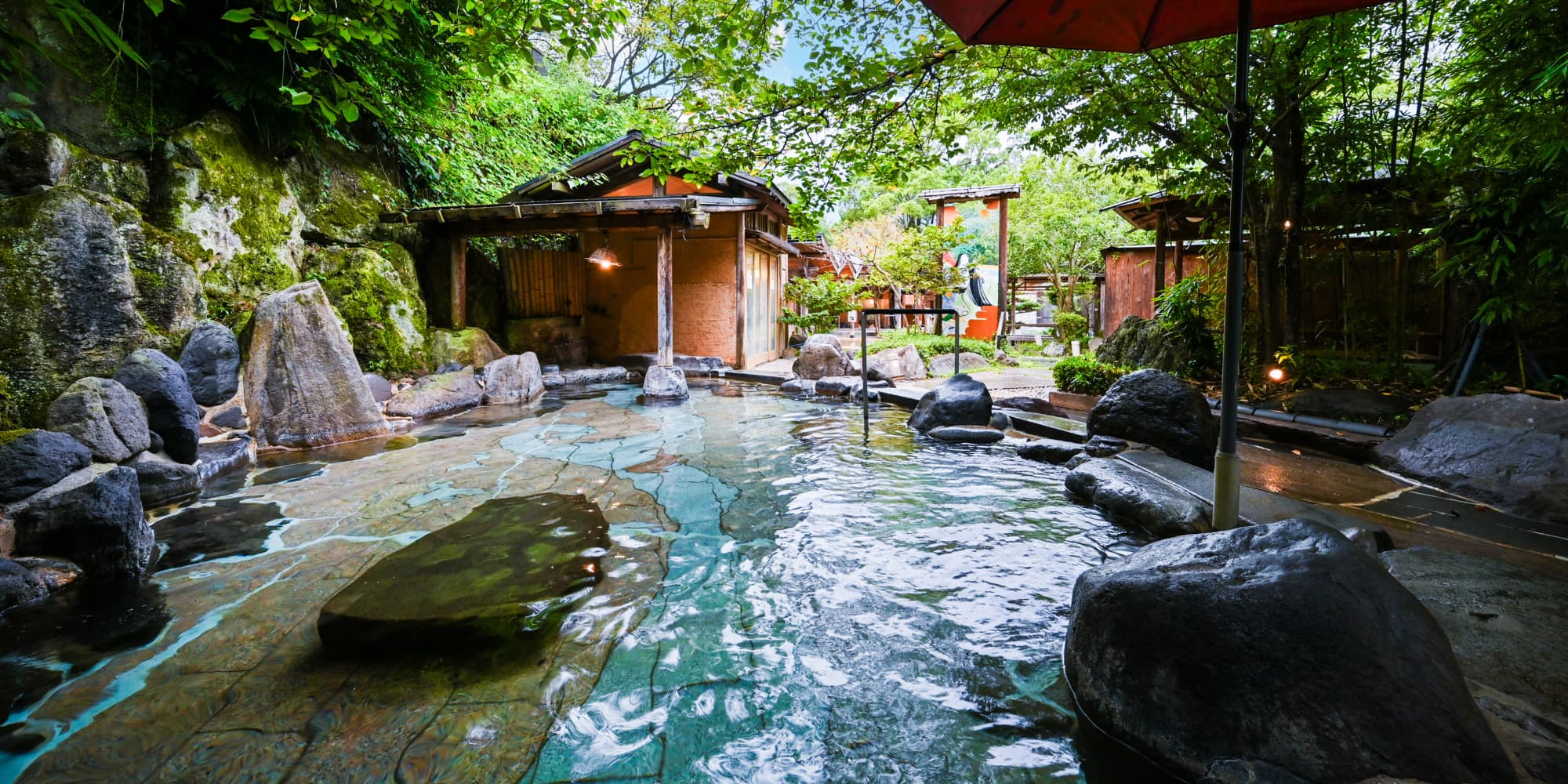 Open-air rotenburo onsen at Nansuikaku surrounded by rocks and lush greenery