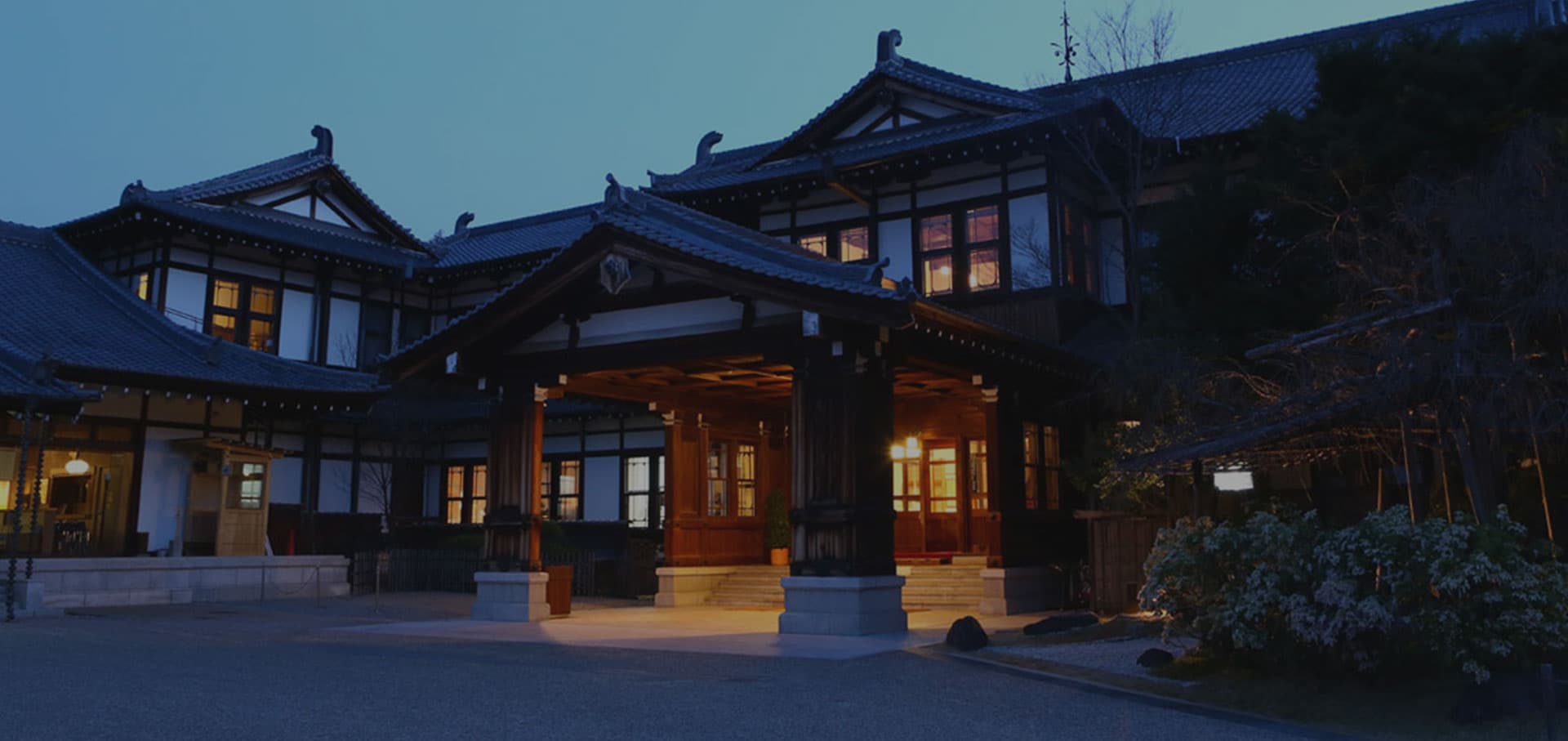 Nara Hotel historic wooden main building with tiled roofs and lit entrance porch at dusk, near Nara Park