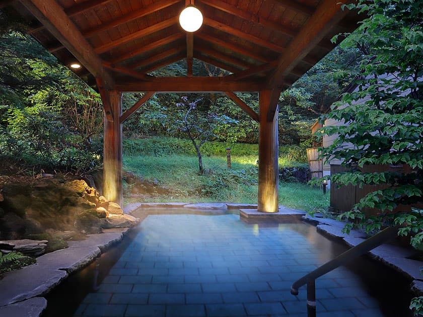 Roofed open-air riverbed bath with a wooden pavilion