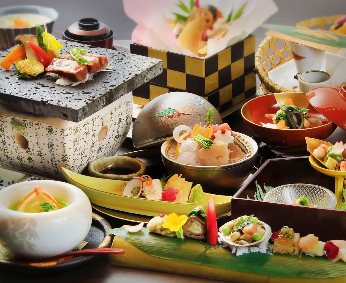 Multi-course kaiseki dinner spread at Fuji Onsenji Yumedono with seasonal dishes on lacquerware and lava-stone plates