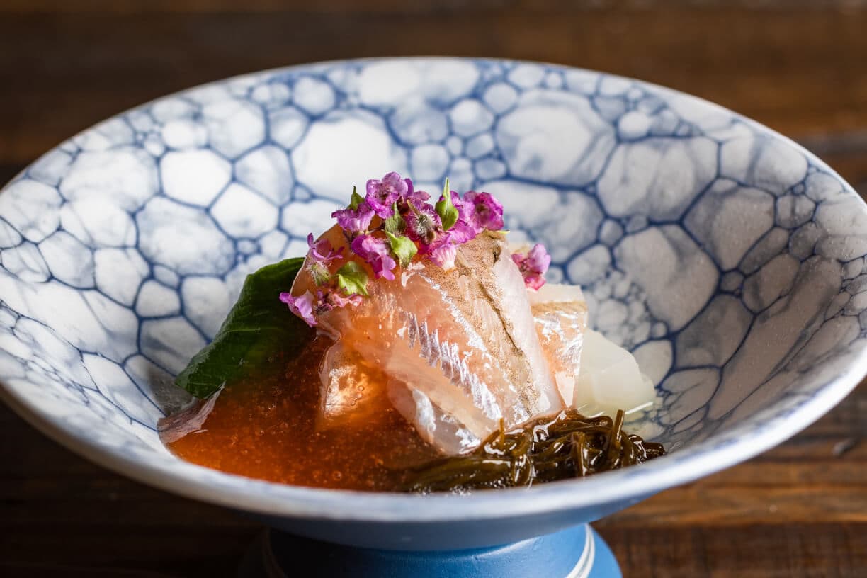 Kaiseki sashimi course at Tsuchiya, sliced fish with ikura and edible flowers in a blue-and-white footed bowl