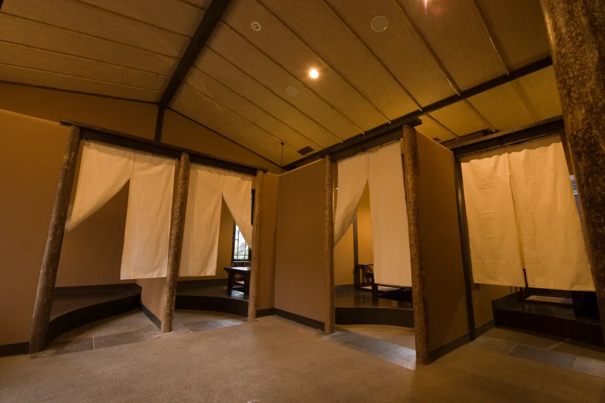 Noren-curtained private dining alcoves at Oyado Uchiyama with timber pillars and stone flooring