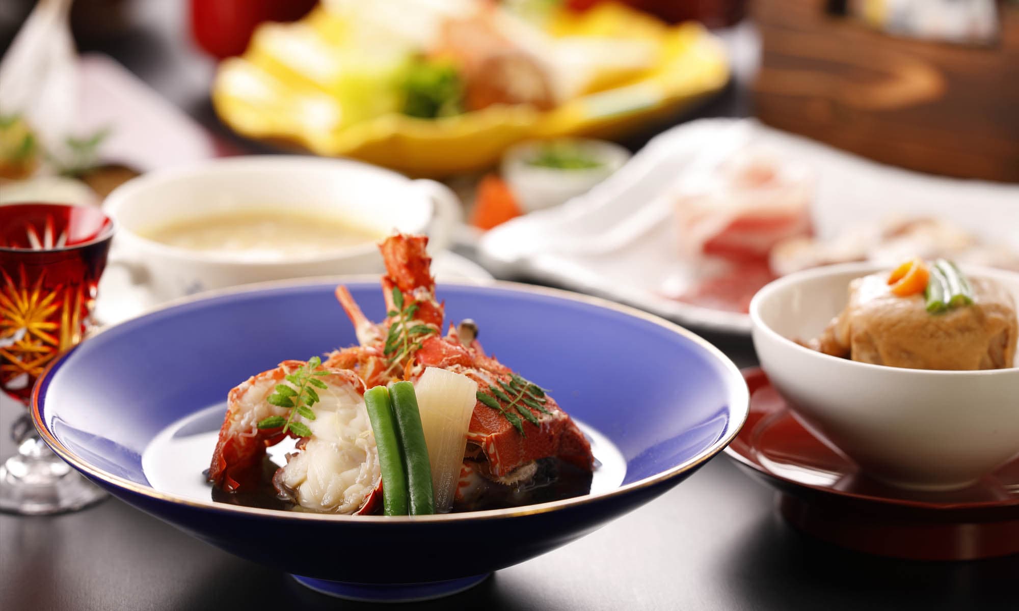 Plated lobster kaiseki course at Ibusuki Shusuien served on blue and gold porcelain