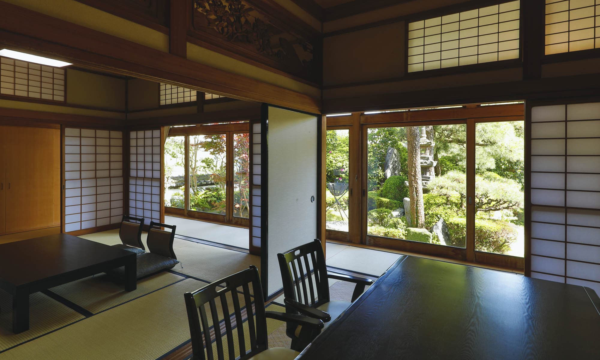 Garden-view tatami guest room at Ibusuki Shusuien with shoji screens and low dining tables