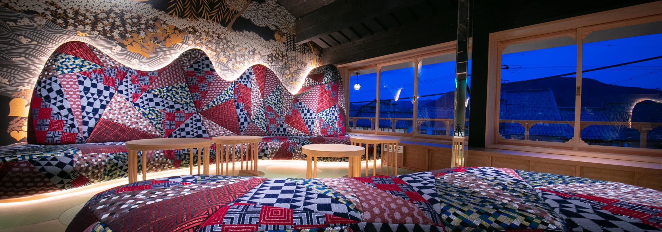 Tokitotoki guest suite with patchwork textile feature wall and night view of Kinosaki