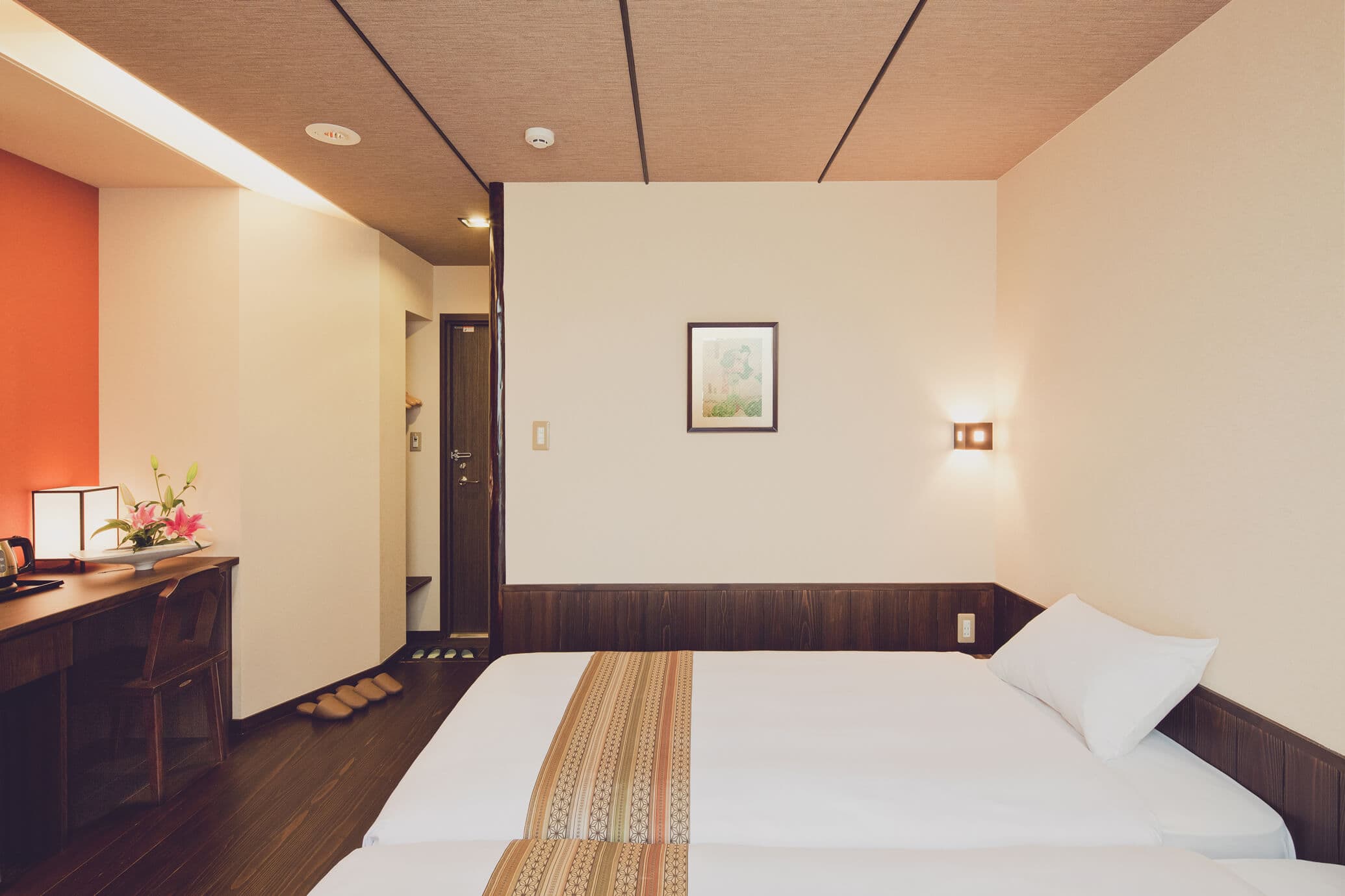 Western-style twin guest room with dark wood floor, desk and framed art at The Edo Sakura, Tokyo