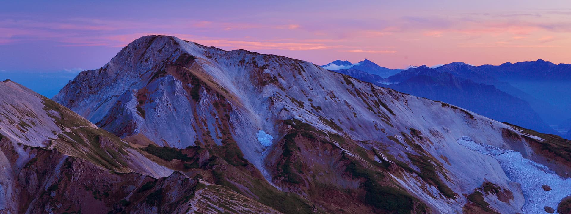 Pink alpenglow over the rugged Hakuba mountain range at sunset, the scenery surrounding Hakuba Tokyu Hotel