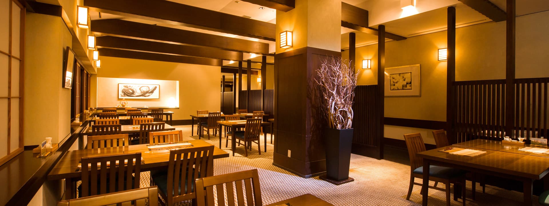 Warmly lit Japanese restaurant Manyo at Hakuba Tokyu Hotel with wooden tables and traditional lantern fixtures
