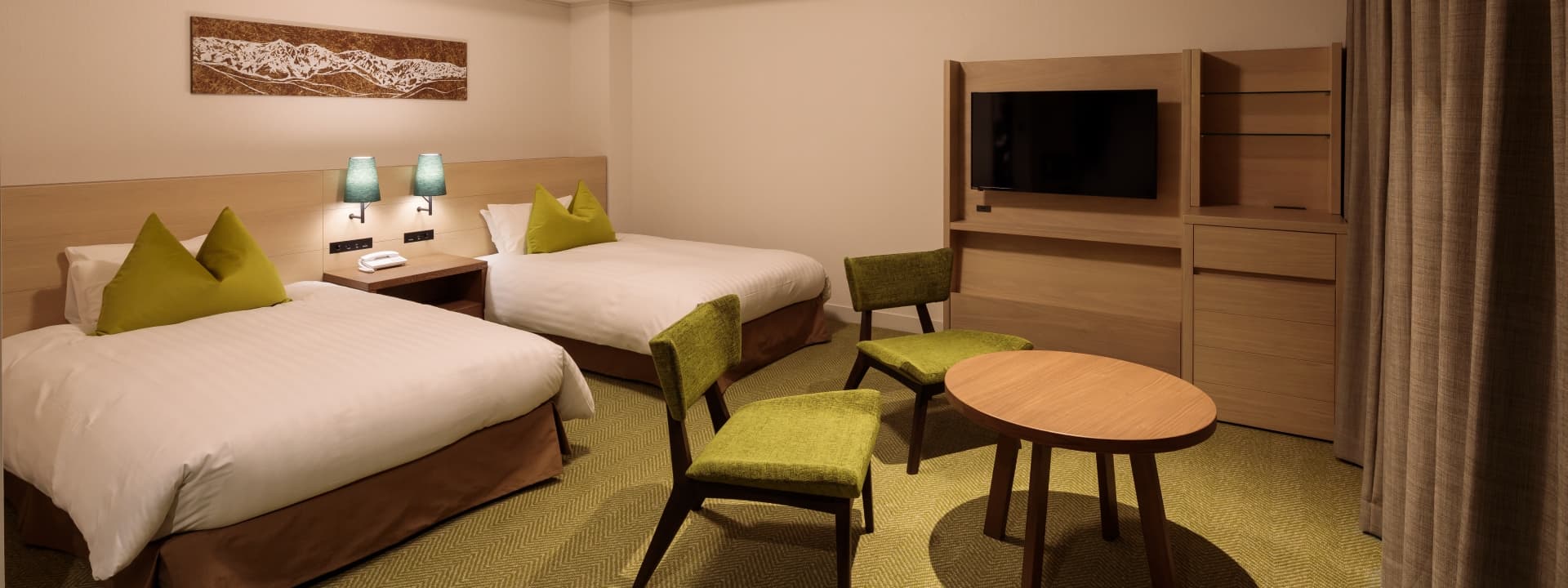 Modern twin guest room at Hakuba Tokyu Hotel with green accents and a framed mountain artwork above the beds
