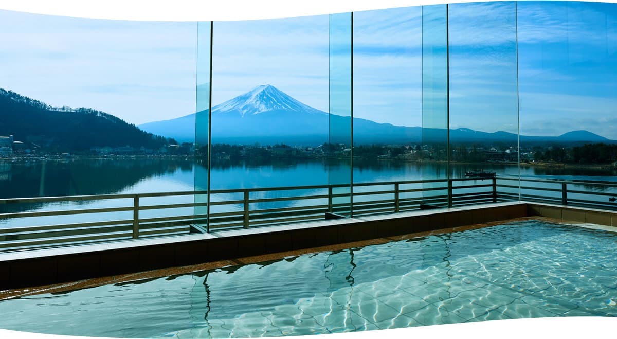 Indoor onsen bath at Kozantei Ubuya with floor-to-ceiling glass framing Mt. Fuji and Lake Kawaguchiko