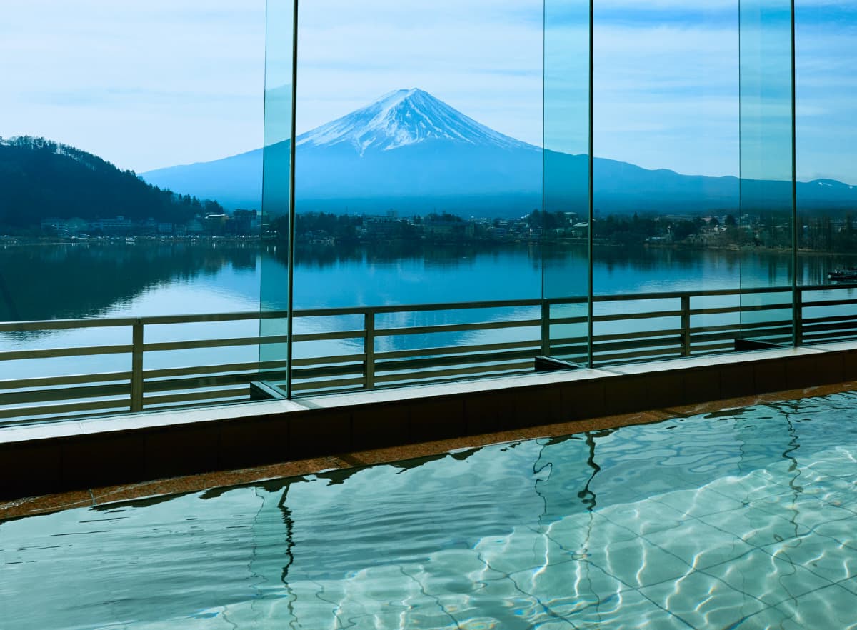 Panoramic indoor bath at Kozantei Ubuya with still water reflecting the snow-capped Mt. Fuji view