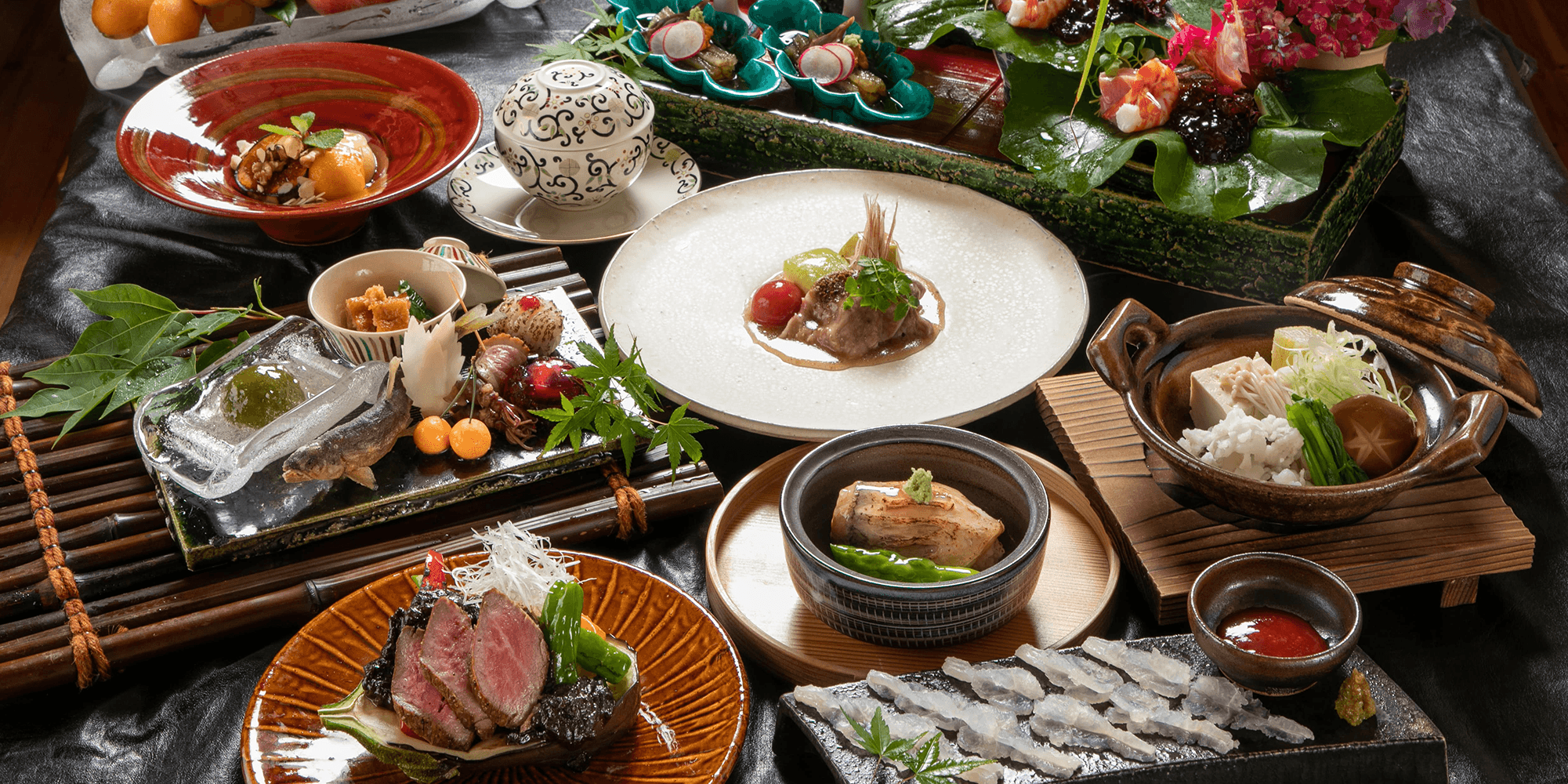 Kaiseki dinner spread of multiple seasonal courses including grilled beef and hot pot at Oyado Den Rikyu