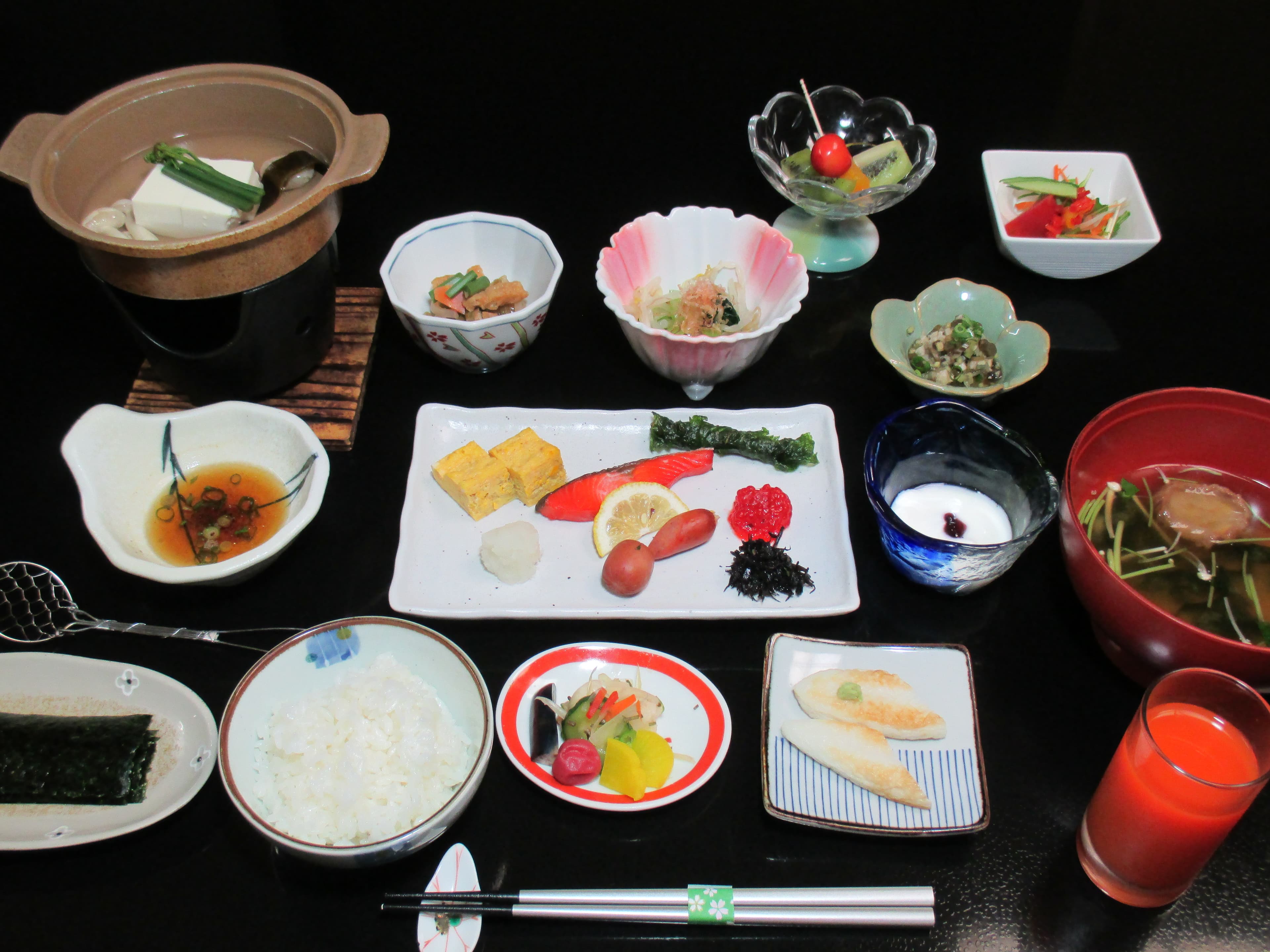 Traditional Japanese breakfast set at Yusaya Ryokan with rice, grilled fish, tofu hot pot and small side dishes
