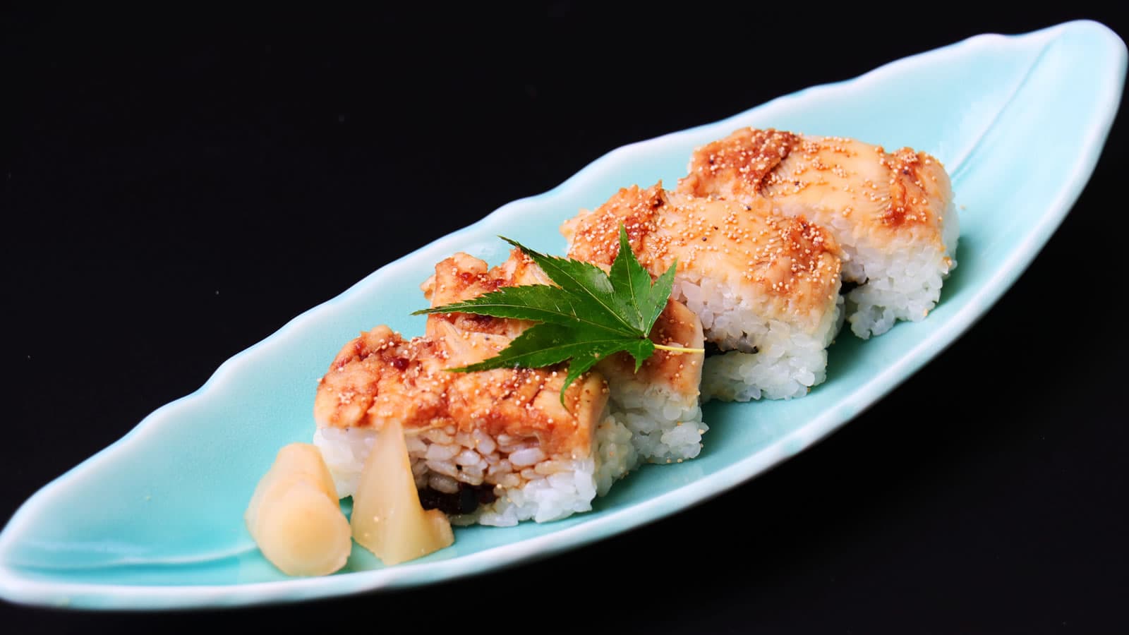 Anago conger eel pressed sushi, a Miyajima specialty, plated on a leaf-shaped dish at Yamaichi Bekkan