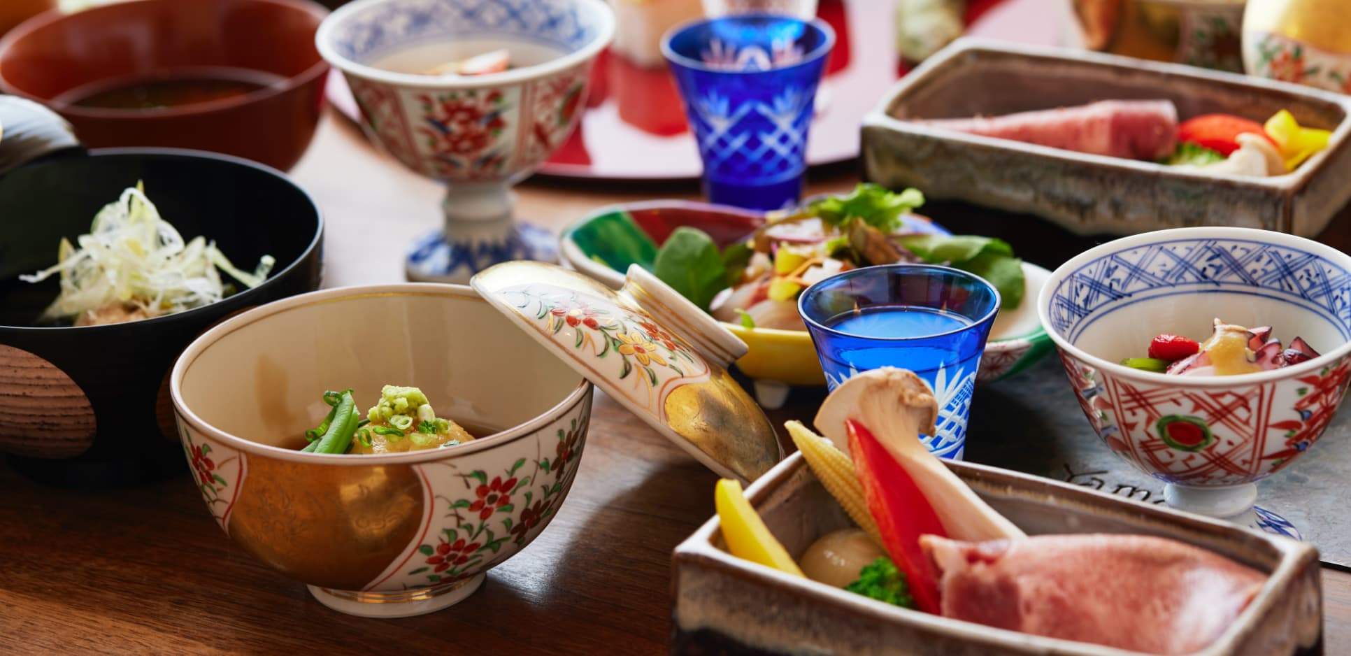 Kaiseki dinner spread served in hand-painted ceramic and cut-glass vessels
