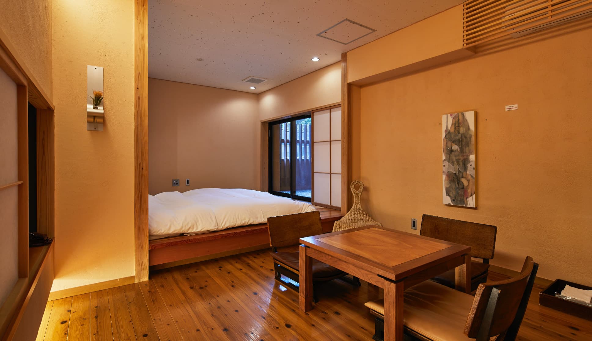 Design guest room with a raised bed, wooden table and paper screens