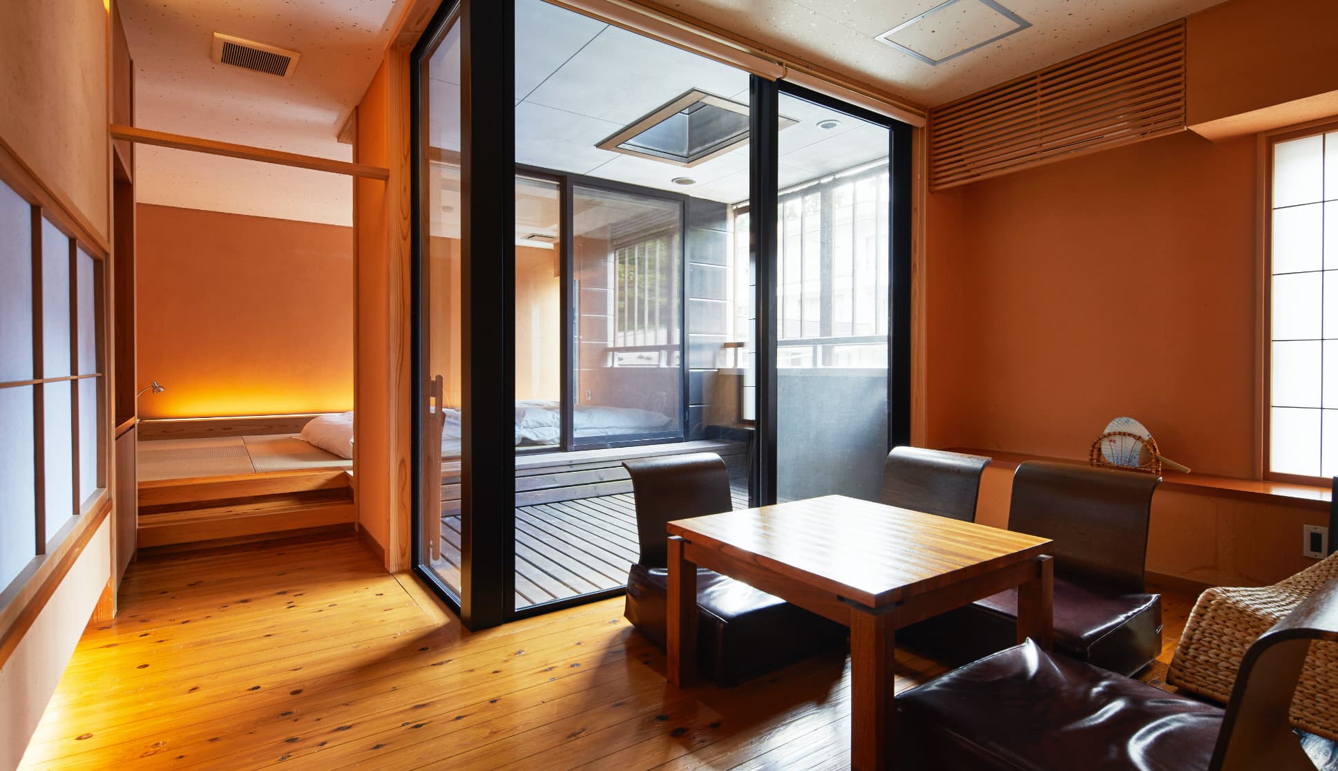 Guest room with lounge seating, terrace and warm ochre plaster walls