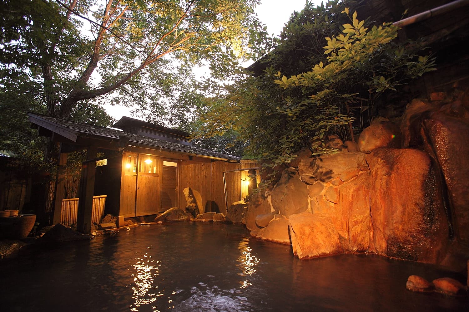 Ryokan Yamanoyu Kodama-no-yu open-air rotenburo rock bath surrounded by greenery at dusk