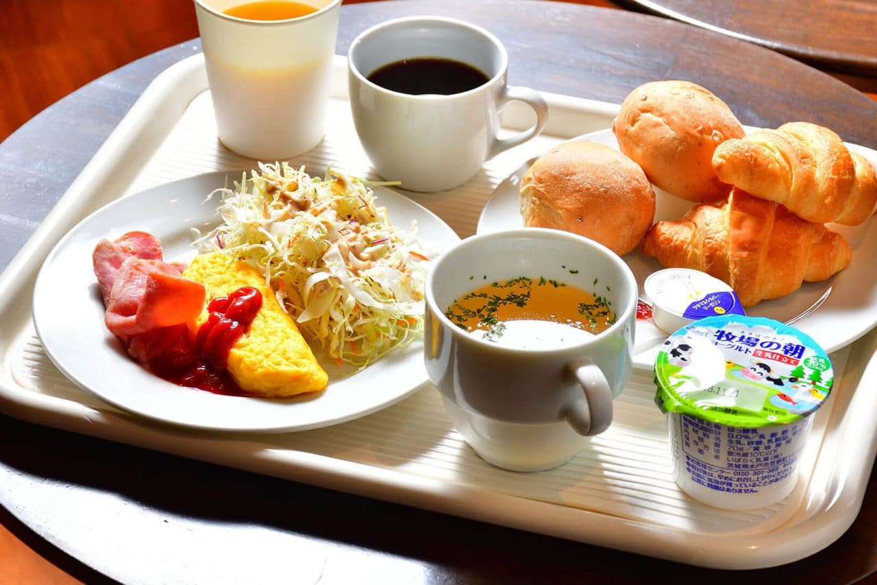 Western-style breakfast tray with omelette, salad, fresh bread, coffee, juice and yogurt