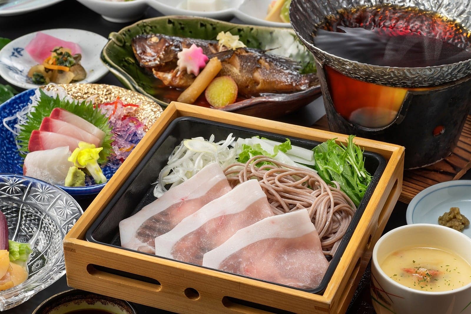 Kaiseki dinner spread with sashimi, grilled fish and a steamer of sea bream and soba at Yumoto Tamaikan