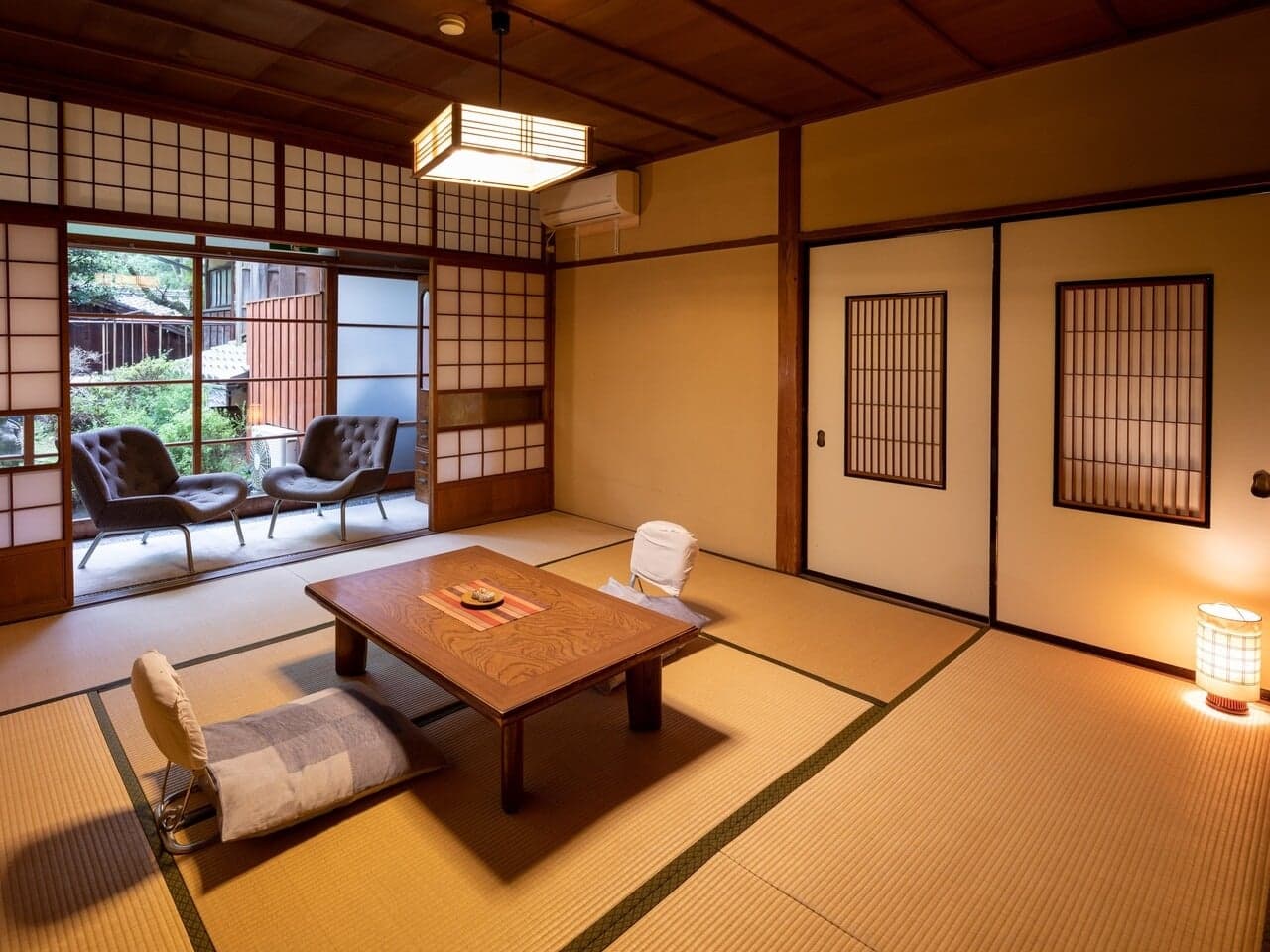 Spacious tatami guest room with shoji screens and a sunlit window seating nook at Yumoto Tamaikan