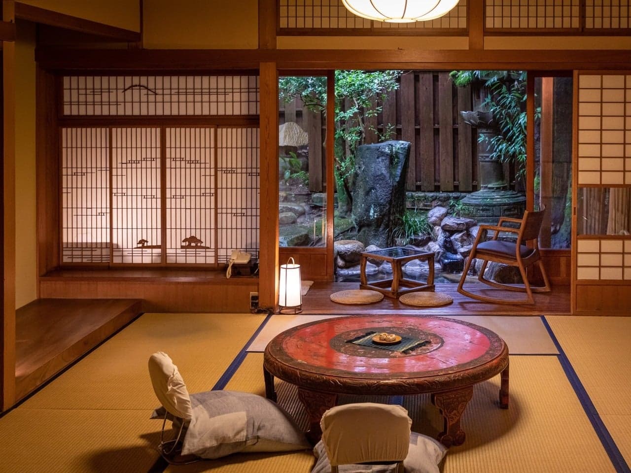 Premium tatami guest room with a round lacquer table opening onto a private stone garden at Yumoto Tamaikan