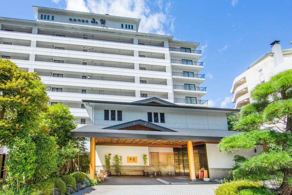 Front exterior of the ryokan on a clear day with landscaped garden
