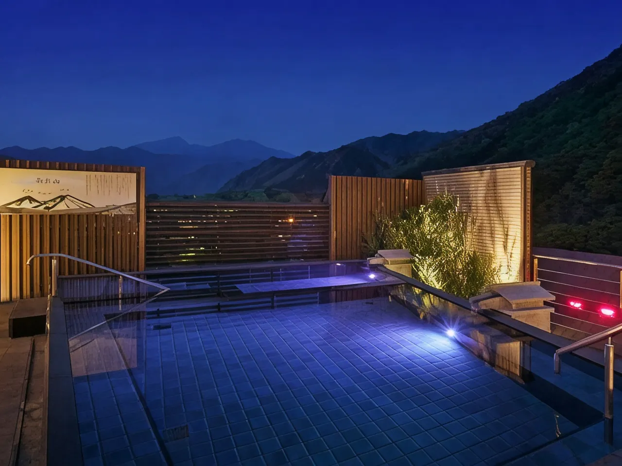 Rooftop sky-garden open-air hot spring bath at dusk with mountain views