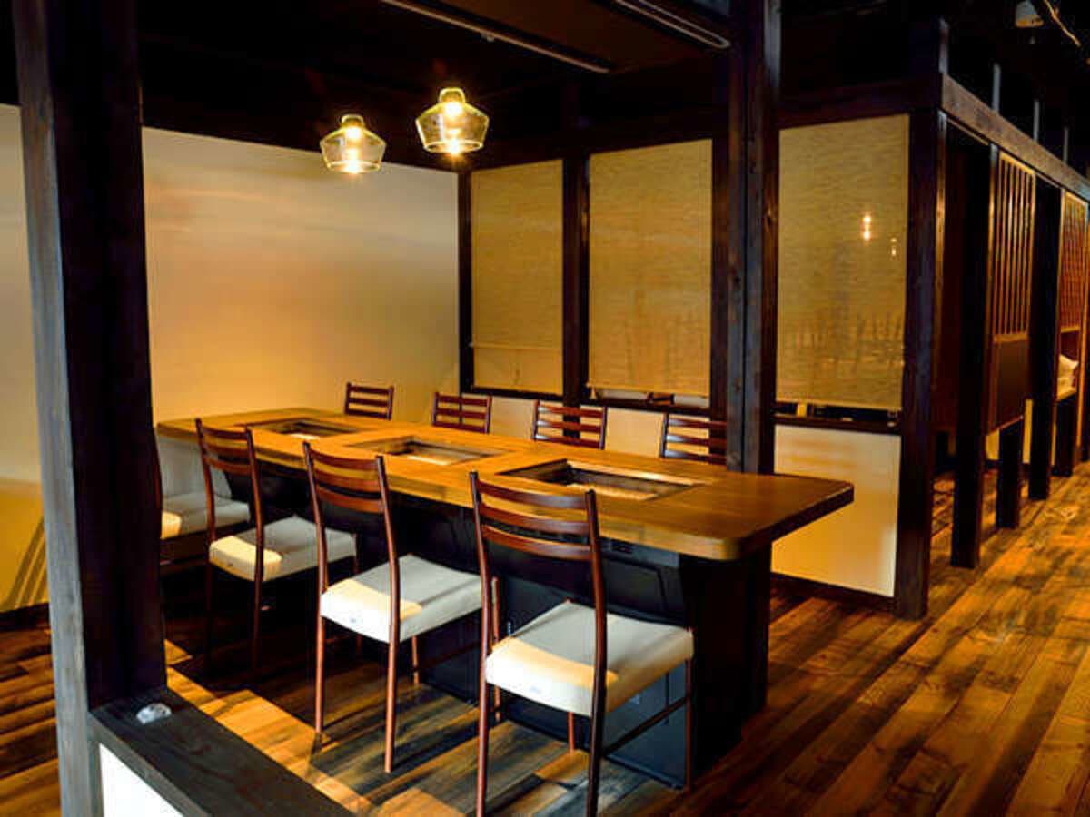 Intimate irori grill dining room with timber beams and bamboo screens under lantern lighting, Koyado En, Kinosaki Onsen