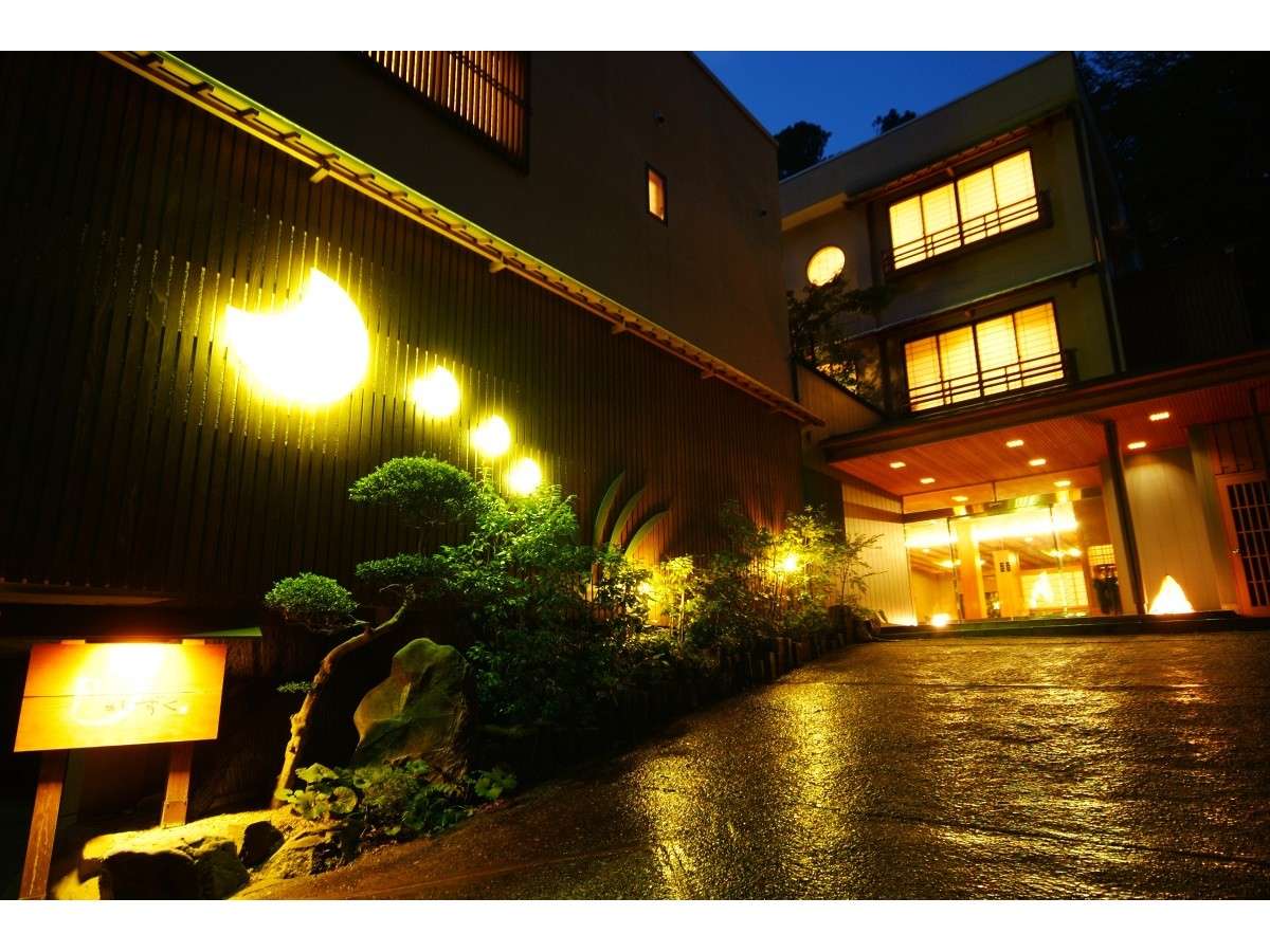 Night exterior of Tsuki no Shizuku reflected in water in Kinosaki Onsen