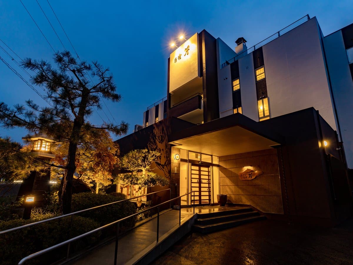 Oyado Seri ryokan exterior in Kinosaki Onsen illuminated at dusk