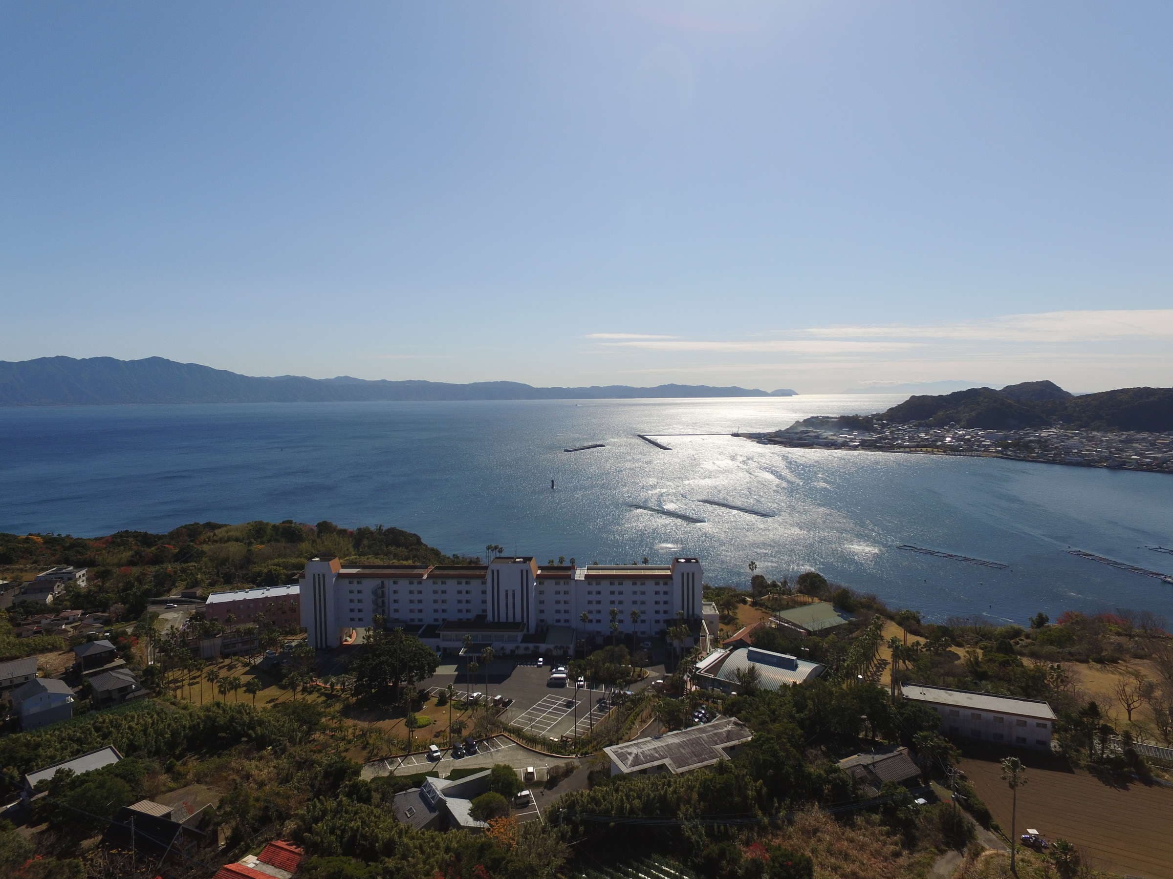 Panoramic aerial of Ibusuki Phoenix Hotel on the coast overlooking the sparkling Ibusuki bay and townscape