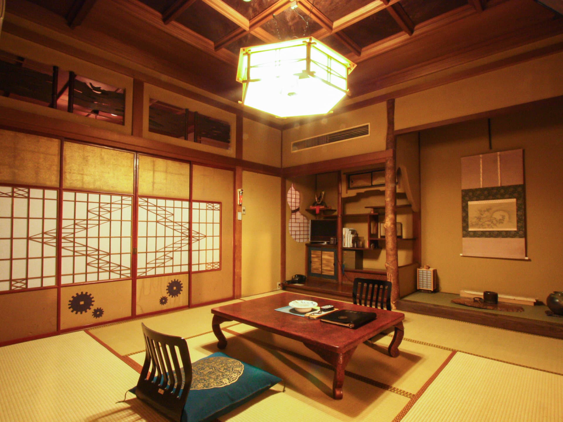 Tatami guest room with a low table, hanging square lantern and carved transom