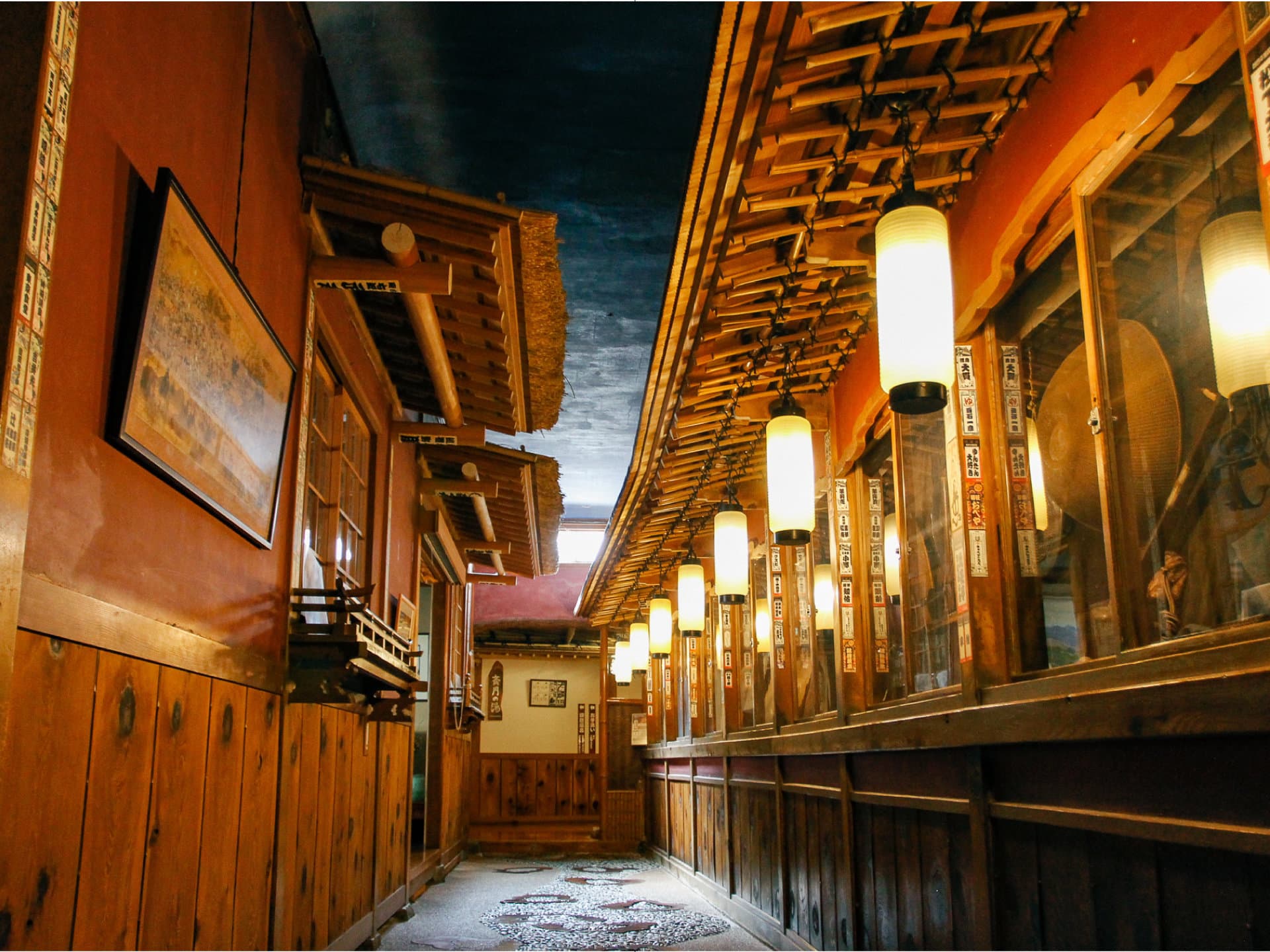 Corridor in the Saigetsuro wing lined with hanging cylindrical lanterns and red-lacquered timber