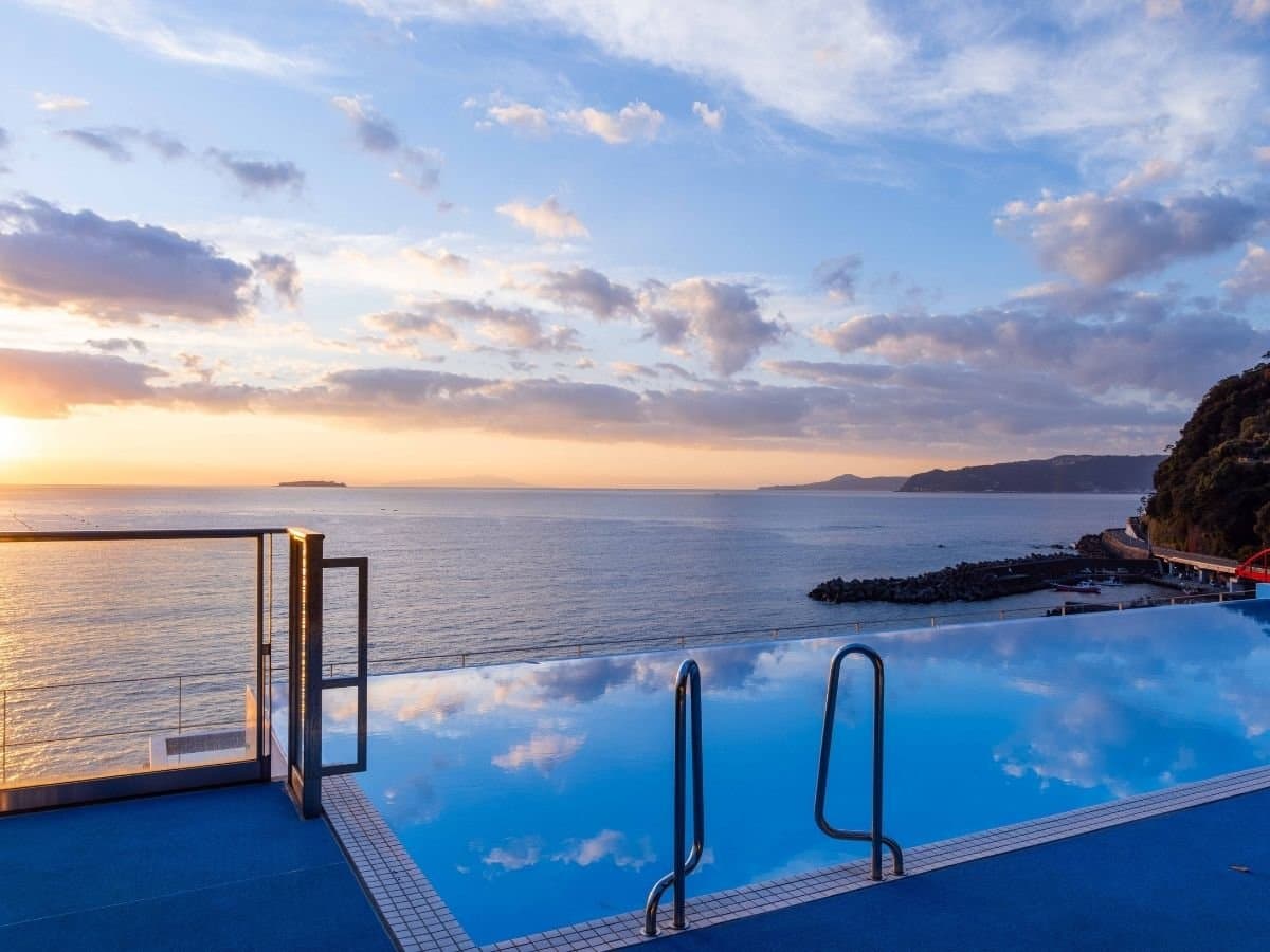 Infinity-edge sea-view bath at sunset over the ocean horizon in Atami