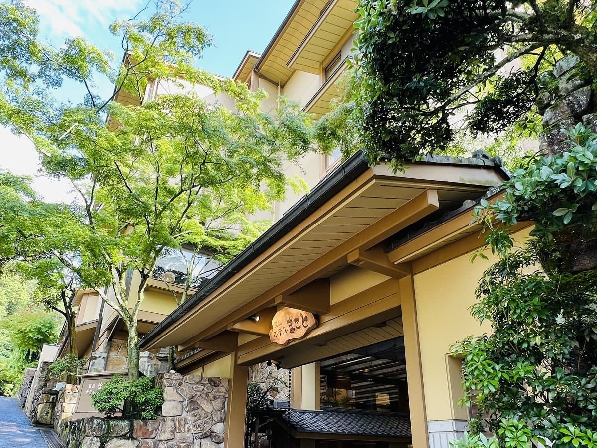 Miyajima Hotel Makoto exterior entrance framed by maples and stone walls on Miyajima island, Hiroshima