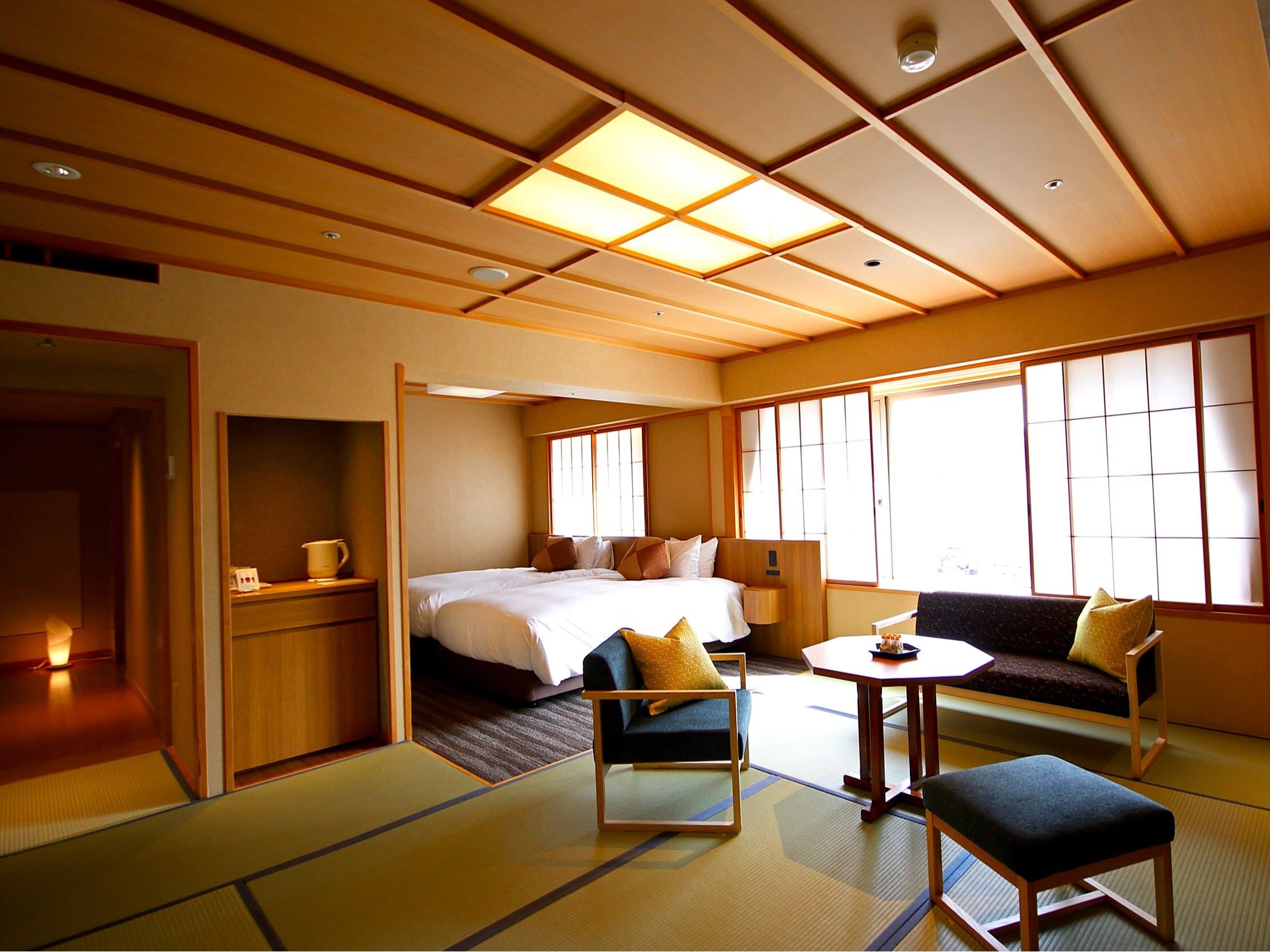Spacious Japanese-Western guest room at Hida Hotel Plaza with twin beds, tatami sitting area and bright windows